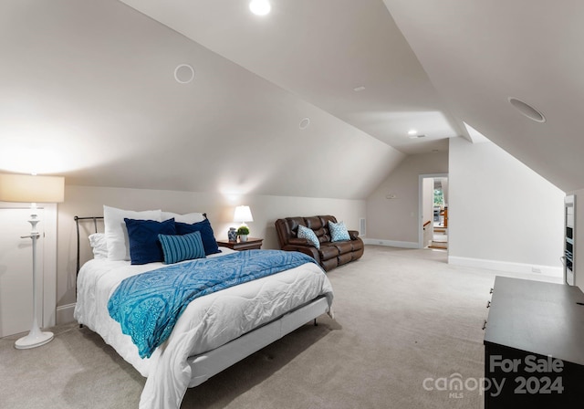 bedroom with light colored carpet and vaulted ceiling