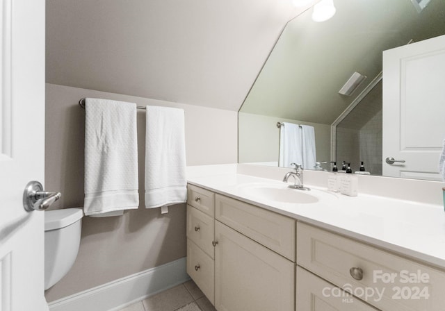 bathroom featuring tile patterned floors, vanity, vaulted ceiling, and toilet