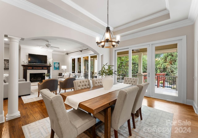 dining space featuring ceiling fan with notable chandelier, dark hardwood / wood-style flooring, ornamental molding, and a tray ceiling