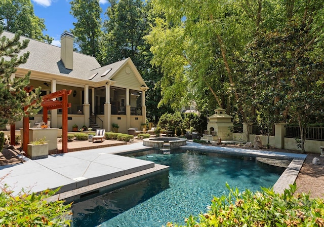 view of pool with an in ground hot tub, a patio, and an outdoor fireplace