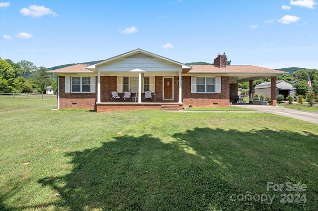 ranch-style home featuring a front lawn, covered porch, and a carport