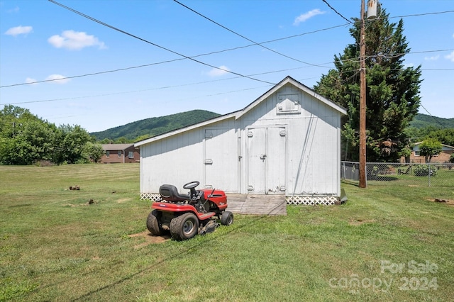 view of outbuilding featuring a mountain view and a yard