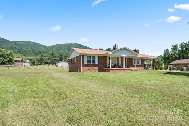 view of front of house featuring a mountain view, a porch, and a front lawn