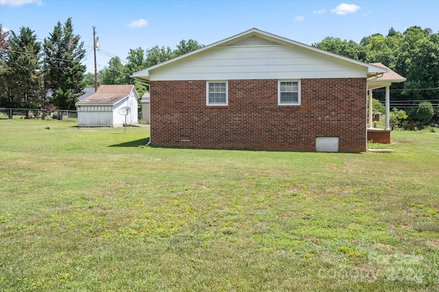 view of side of home featuring a yard and a shed