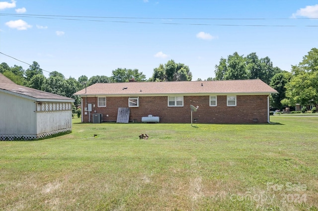 rear view of property with a yard and cooling unit