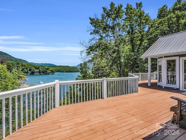 wooden deck featuring a water and mountain view