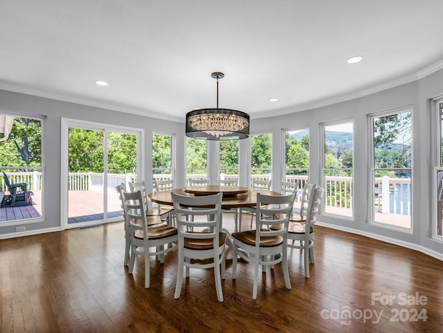 dining room with dark hardwood / wood-style flooring, ornamental molding, and a notable chandelier