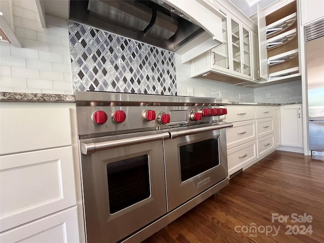 kitchen with white cabinetry, decorative backsplash, dark wood-type flooring, custom range hood, and high quality appliances