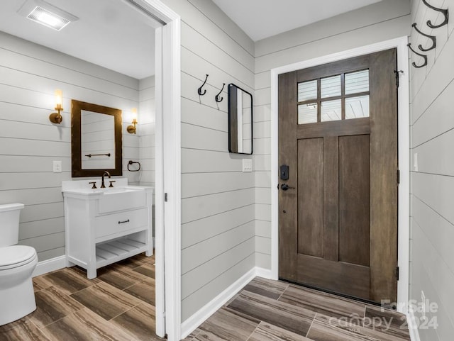 entrance foyer with sink and wooden walls