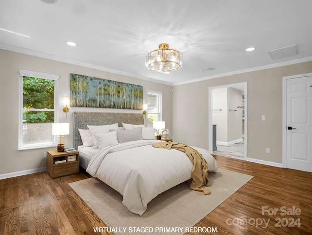 bedroom with dark wood-type flooring, ensuite bathroom, crown molding, and an inviting chandelier