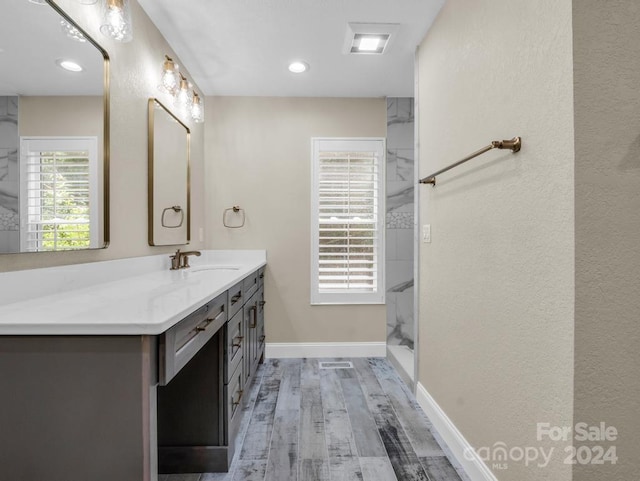 bathroom featuring hardwood / wood-style floors, walk in shower, and vanity