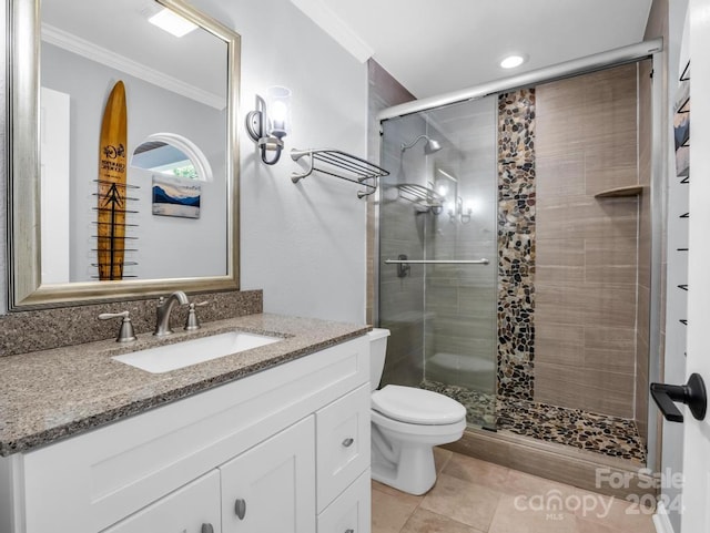 bathroom featuring tile patterned floors, vanity, toilet, walk in shower, and ornamental molding