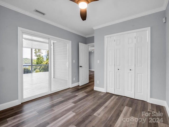 unfurnished bedroom featuring dark wood-type flooring, a closet, access to outside, ceiling fan, and crown molding