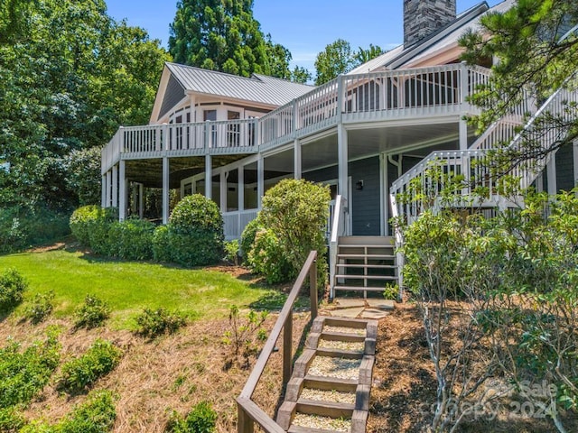 rear view of house with a lawn and a deck