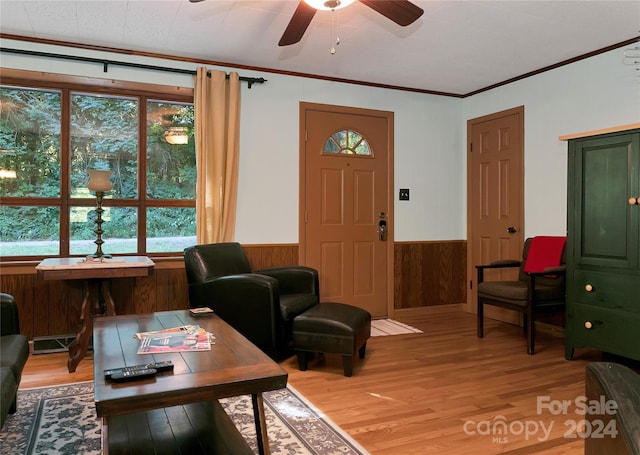 living room featuring hardwood / wood-style flooring, ornamental molding, and ceiling fan