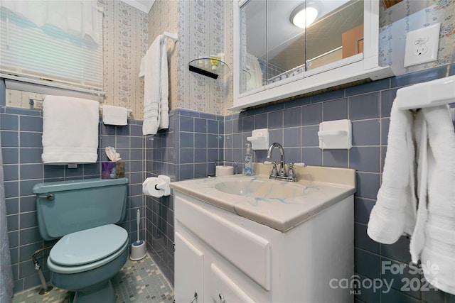 bathroom featuring tile walls, toilet, vanity, and tile patterned flooring