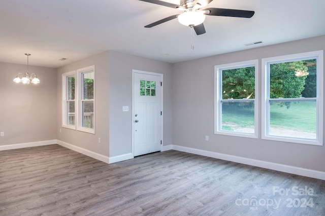 foyer with hardwood / wood-style flooring and ceiling fan with notable chandelier