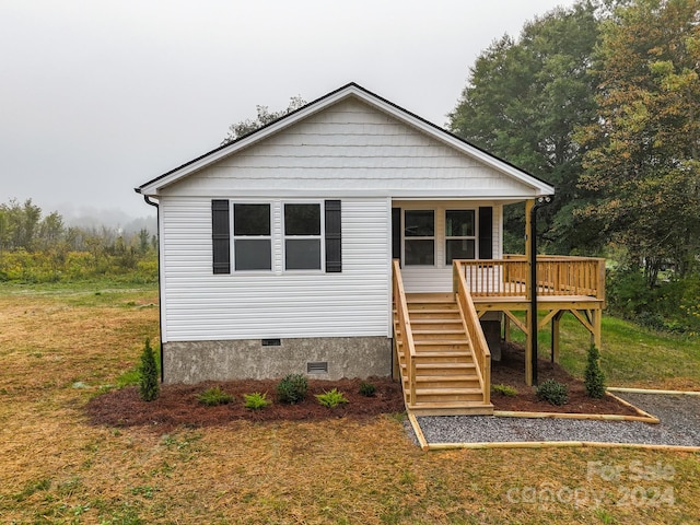 view of front of home featuring a front lawn and a deck