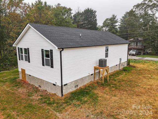 view of home's exterior with a yard and central AC