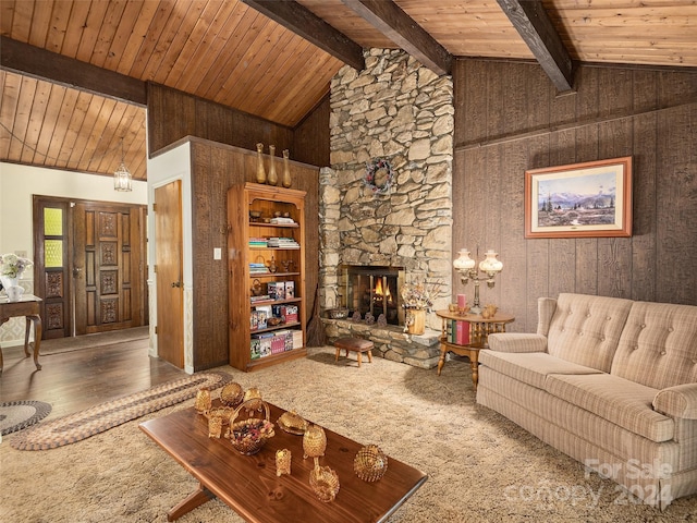 living room featuring wood walls, a fireplace, carpet floors, and beamed ceiling