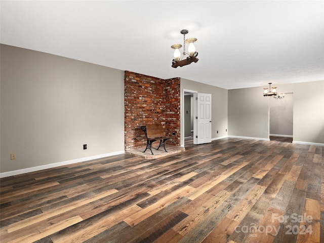 unfurnished living room with dark hardwood / wood-style floors and a chandelier