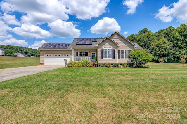 view of front of house featuring a garage, solar panels, covered porch, and a front yard