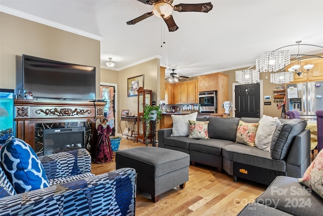 living room featuring light wood-type flooring, a high end fireplace, crown molding, and ceiling fan with notable chandelier