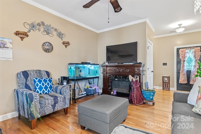 living room with ceiling fan, a high end fireplace, ornamental molding, and hardwood / wood-style flooring