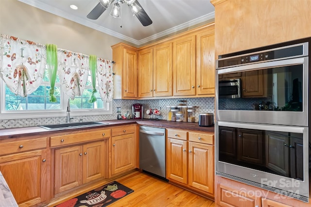 kitchen featuring appliances with stainless steel finishes, crown molding, light hardwood / wood-style floors, and sink