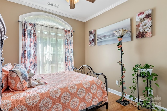 bedroom featuring ceiling fan, wood-type flooring, and crown molding