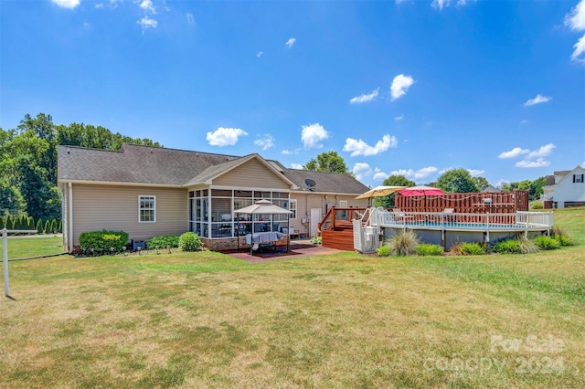 back of property with a sunroom, a swimming pool side deck, and a lawn