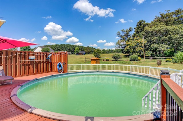 view of pool featuring a lawn and a deck