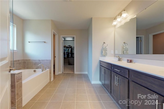 bathroom featuring tile patterned flooring, a bathtub, and vanity