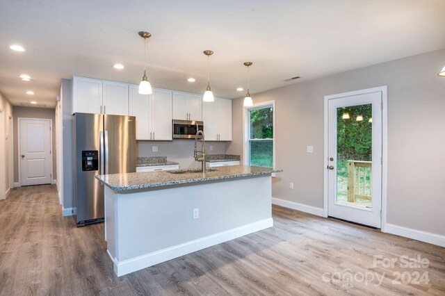 kitchen with a kitchen island with sink, appliances with stainless steel finishes, sink, and white cabinetry