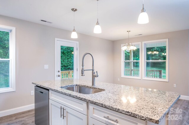 kitchen featuring a kitchen island with sink, dishwasher, light stone countertops, white cabinets, and sink