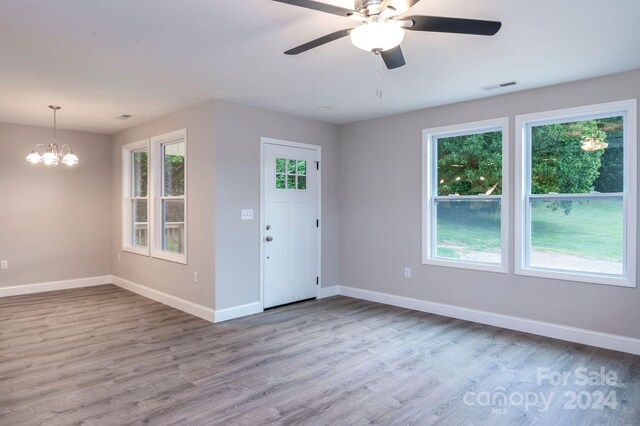 entrance foyer with ceiling fan with notable chandelier and hardwood / wood-style floors