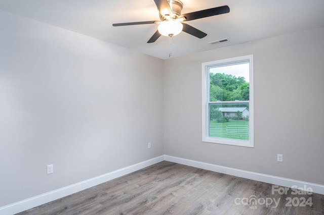 empty room with ceiling fan and light hardwood / wood-style flooring