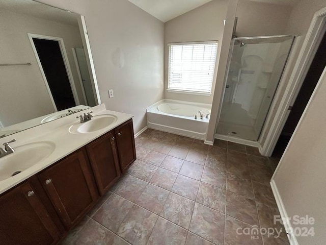 bathroom featuring tile patterned flooring, vanity, independent shower and bath, and vaulted ceiling