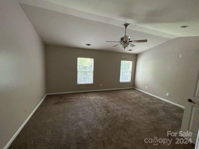 carpeted spare room featuring ceiling fan and vaulted ceiling