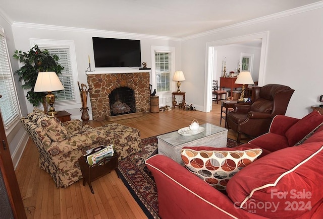 living room with wood-type flooring, a fireplace, and ornamental molding