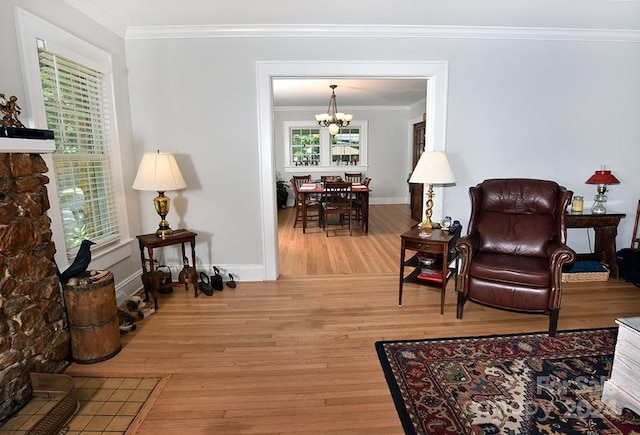 living room featuring an inviting chandelier, crown molding, and hardwood / wood-style flooring