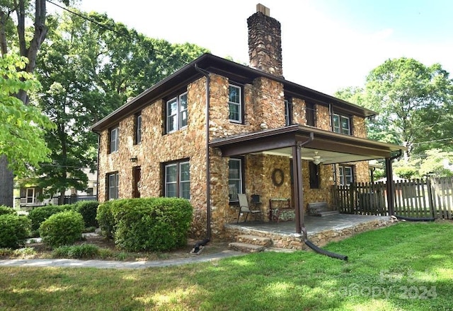 rear view of property featuring a yard