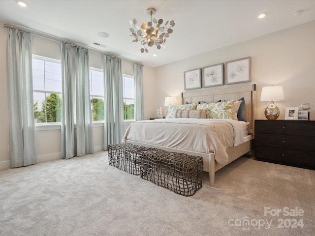 bedroom with multiple windows, light carpet, and a chandelier