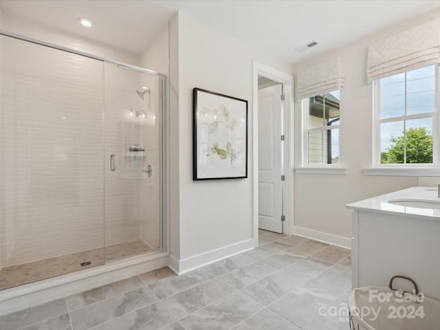 bathroom with a shower with door and vanity