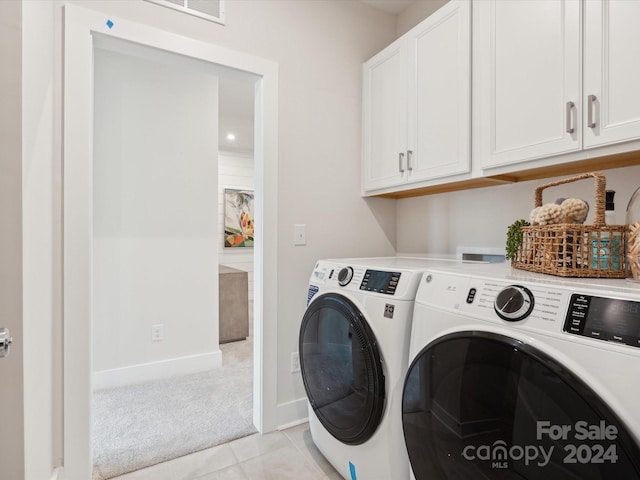 laundry area with cabinets, light tile patterned floors, and independent washer and dryer