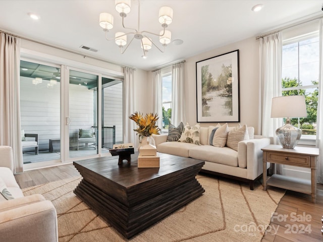 living room with an inviting chandelier and light wood-type flooring