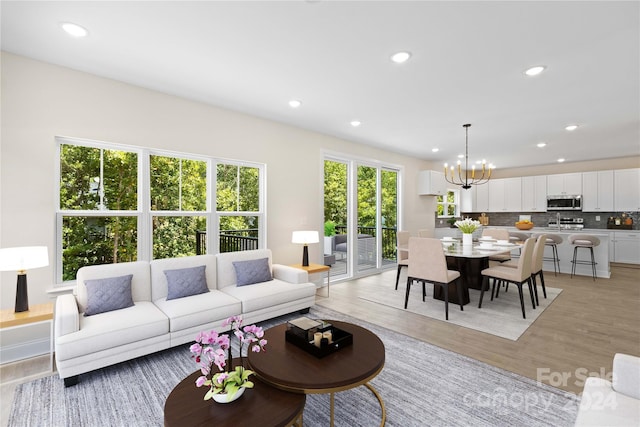 living room with a chandelier and light wood-type flooring