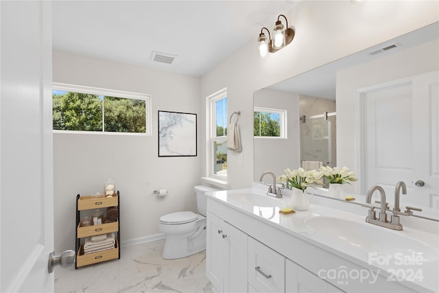 bathroom featuring vanity, toilet, and a shower with shower door