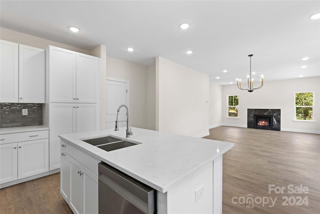 kitchen featuring a kitchen island with sink, sink, stainless steel dishwasher, and white cabinets