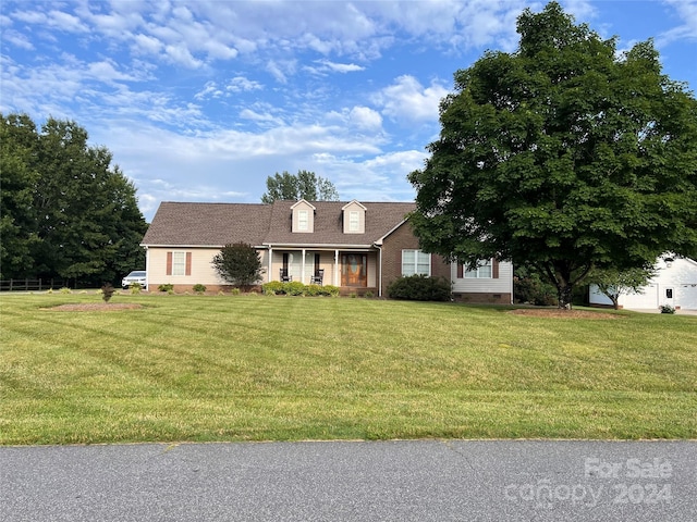 new england style home featuring a front lawn and a porch